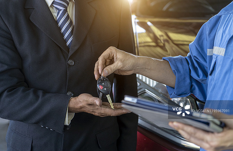车辆检查和维护后交付车钥匙的概念图片素材