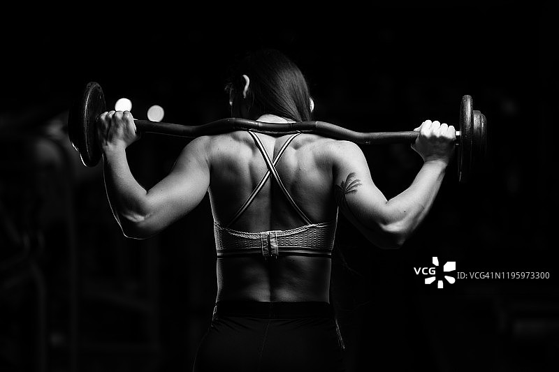 健身房里的英雄姿势和强壮的女孩图片素材