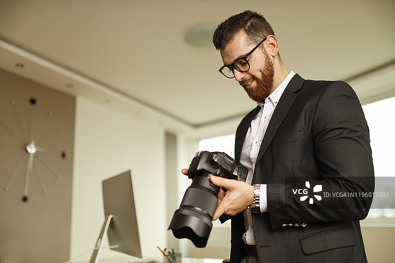 摄影师在办公室里拿着照相机图片素材