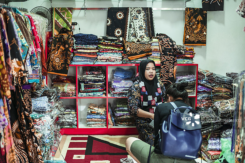 在爪哇岛购买印尼传统服装巴迪布的东南亚妇女图片素材