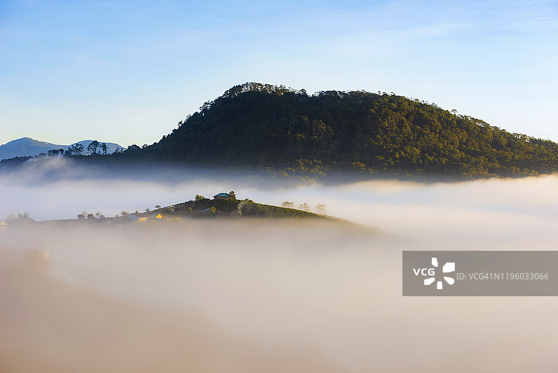 雾和日出光芒下山坡小屋美景图片素材