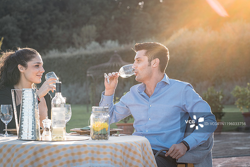 情侣在托斯卡纳别墅外品酒图片素材