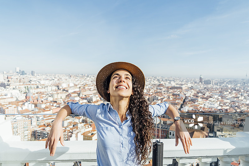 戴着帽子，背景是西班牙马德里城市的美丽女人图片素材