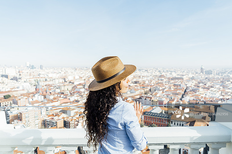 戴着帽子，背景是西班牙马德里城市的美丽女人图片素材