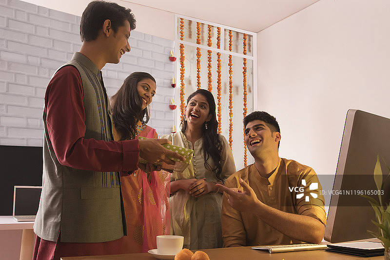 在排灯节庆祝活动中，员工在办公室给同事送礼物图片素材