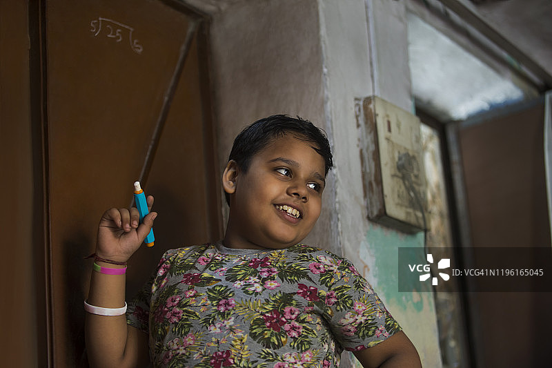 在门上写数学题的男孩图片素材