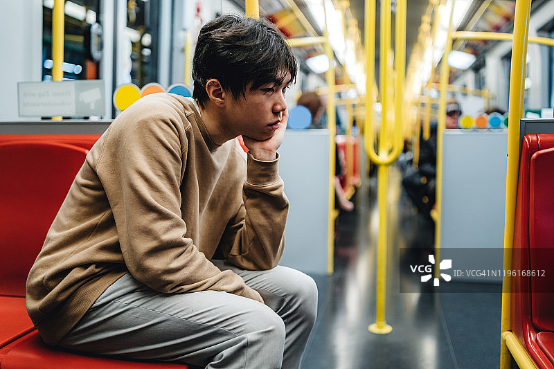 地铁里悲伤的青少年男孩图片素材