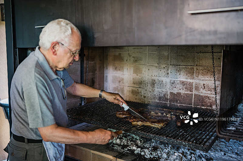 年长的男人在家烧烤肉类图片素材