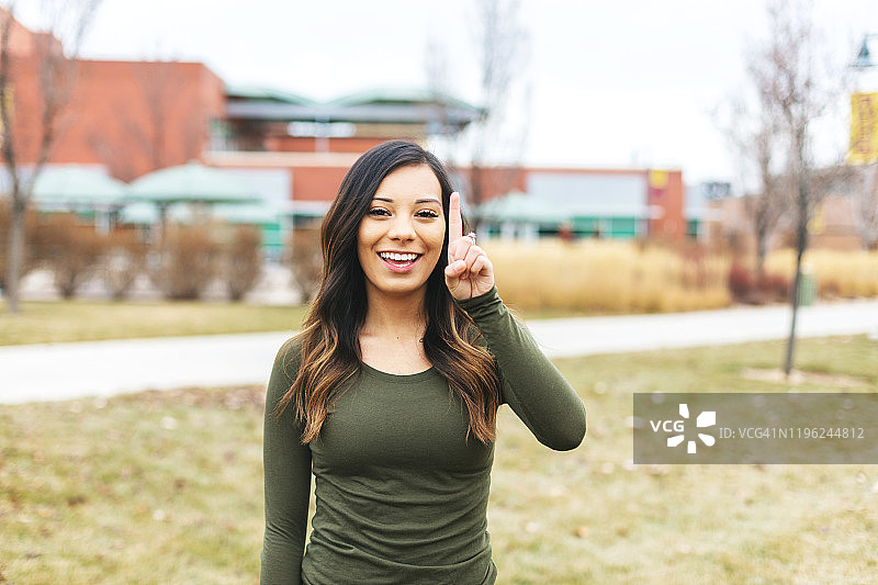 指着数字“一”的西班牙裔女大学生图片素材