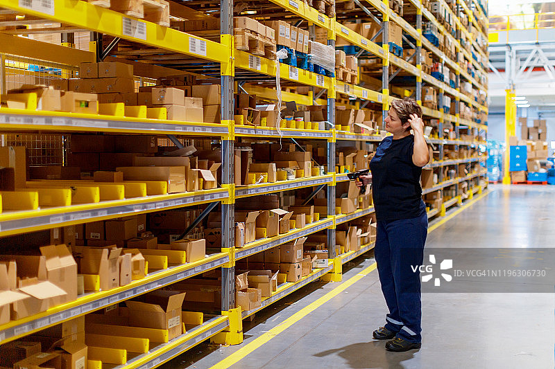 仓库工人扫描货架寻找物品图片素材