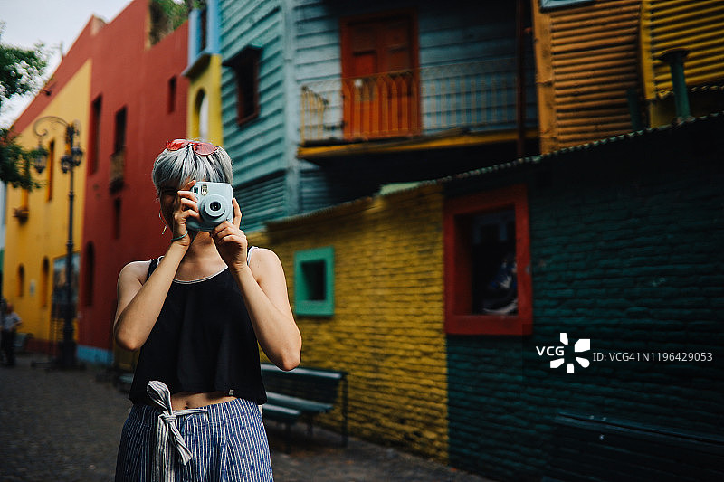 女孩用宝丽来相机拍照图片素材