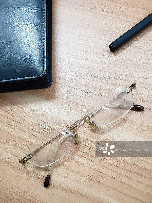 桌子上的眼镜、笔记本和笔图片素材