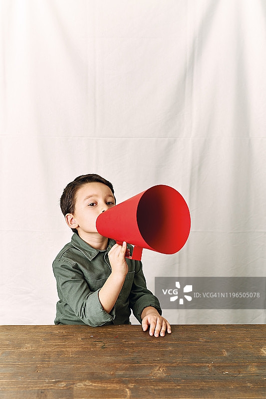 6-7岁可爱儿童用扩音器喊话图片素材