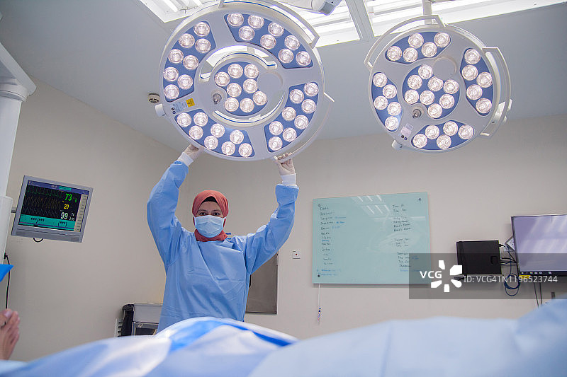 护士调整手术灯，准备手术操作图片素材