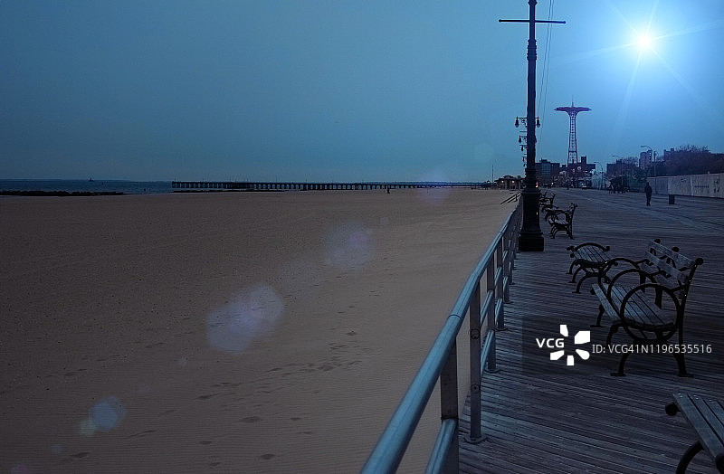 纽约市布鲁克林区康尼岛木板路上的长椅夜景图片素材