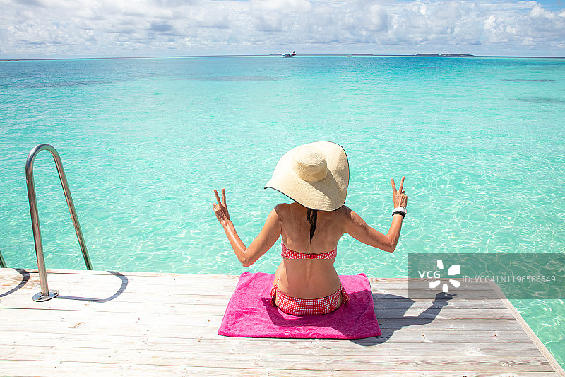 女孩坐在海边的甲板上图片素材