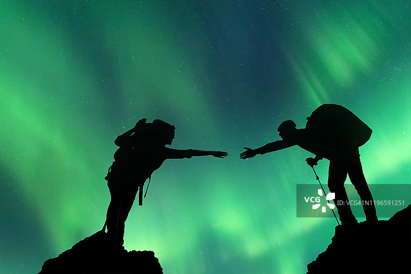 伸出援手帮助朋友的剪影：团队合作概念图片素材