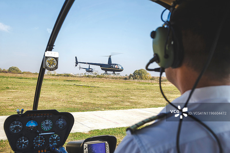 飞行员观看直升机在机场降落图片素材