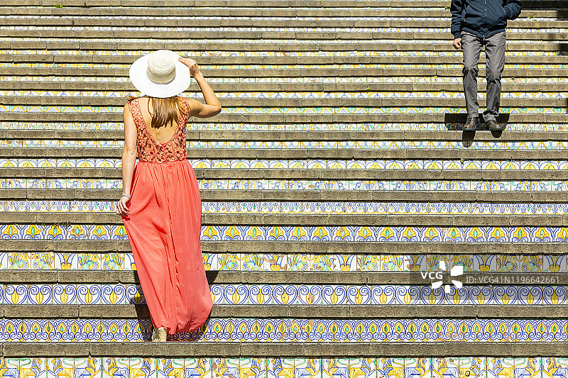 年轻女子在意大利西西里卡尔塔吉罗内的瓷砖楼梯上行走图片素材