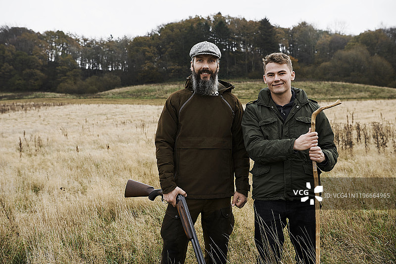 携带狩猎设备的男子和青年男子肖像图片素材