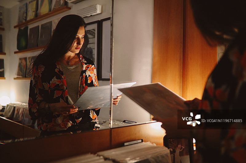 女孩在唱片店里翻看唱片图片素材
