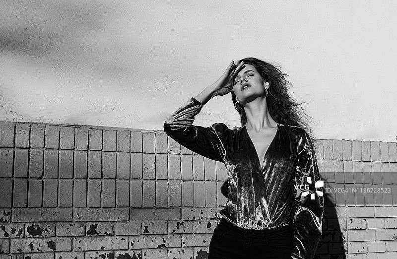 站在街上，用阴影遮挡阳光的女人图片素材