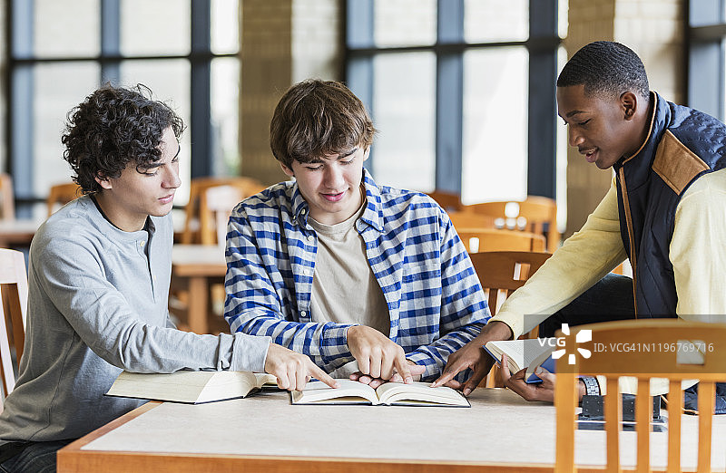 高中图书馆里一起学习的青少年男孩图片素材