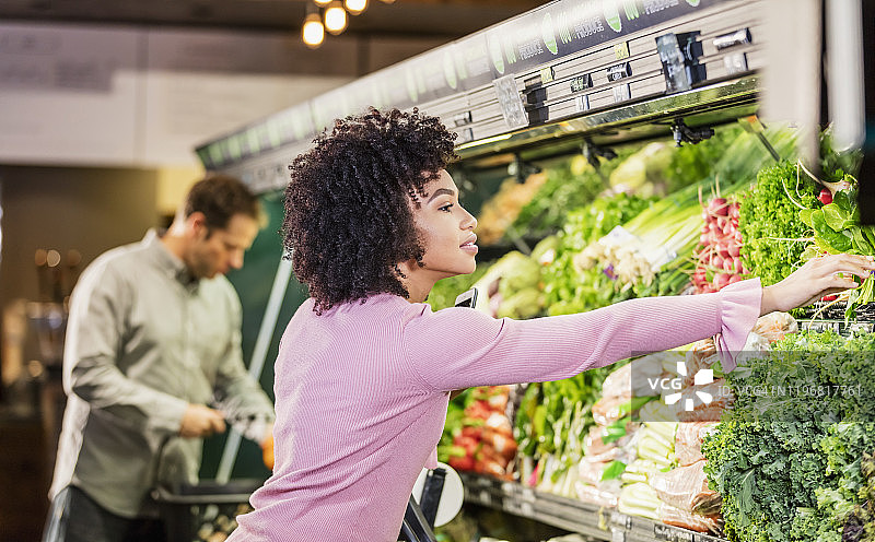 年轻的非裔美国女性在食品杂货店购物图片素材