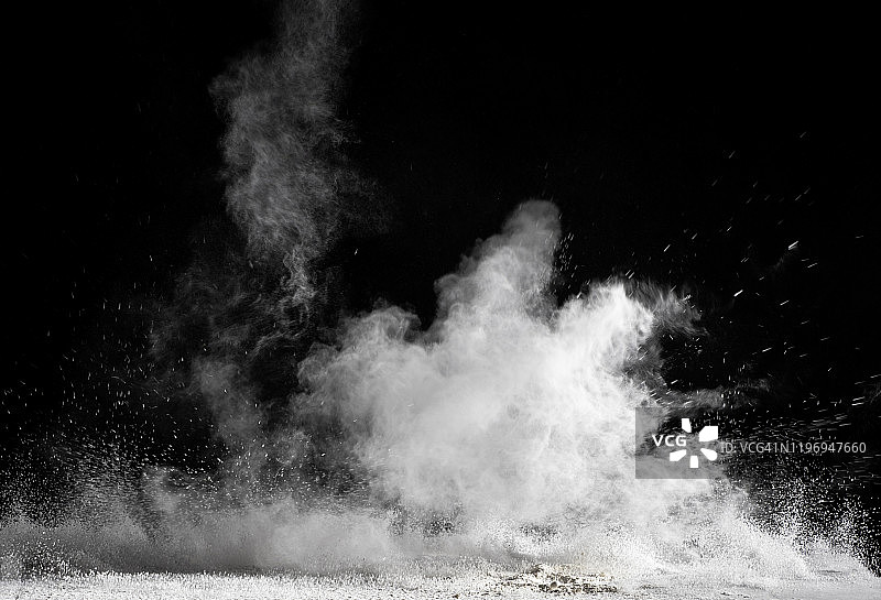 黑色背景上白色粉末颗粒云的爆炸冲击图片素材
