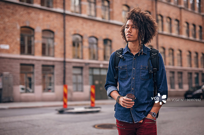 在城市里喝咖啡的时尚男人图片素材