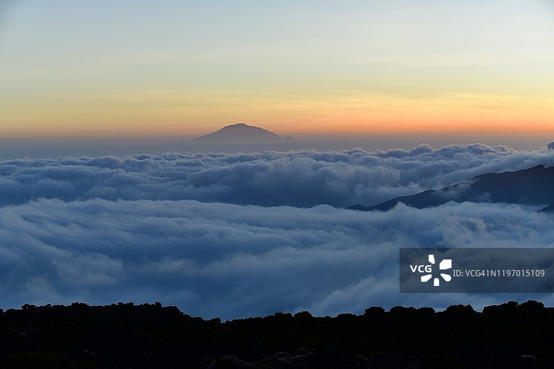 黄昏时分云层之上的梅鲁火山图片素材