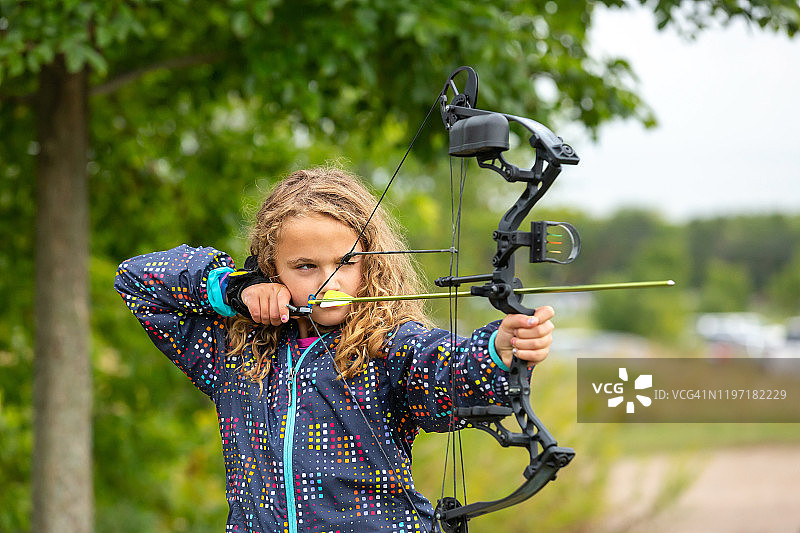 年轻女孩在户外靶场练习射箭图片素材