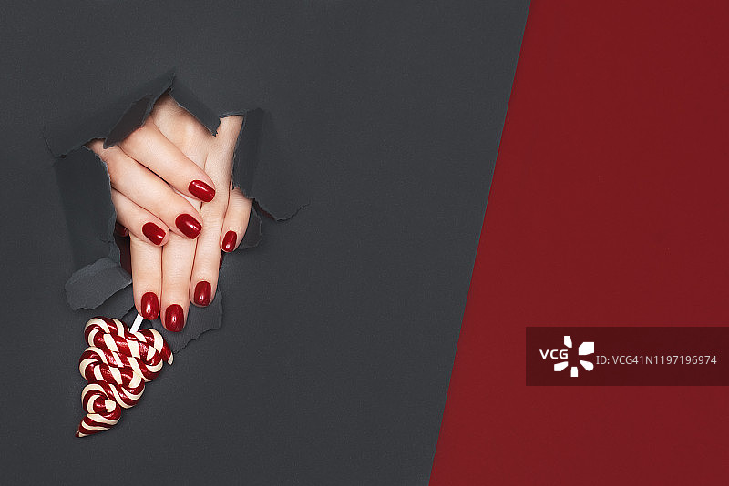 女人手部涂着闪亮的红色指甲油，美甲和指甲护理概念图片素材