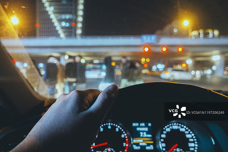 男子在夜间十字路口开车图片素材