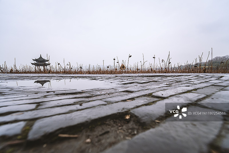 雨后杭州西湖边水洼中汲贤亭的倒影图片素材