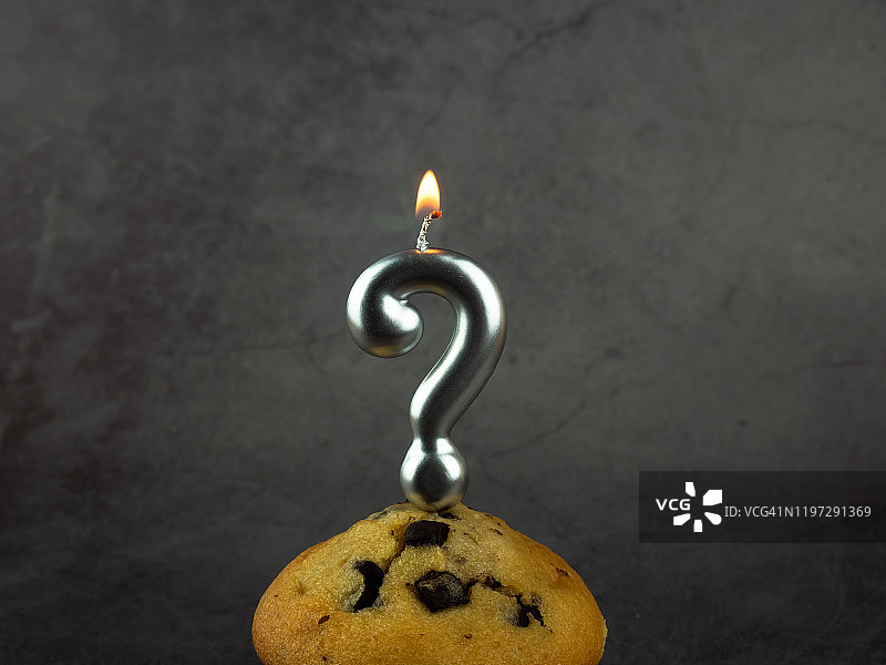 纸杯蛋糕上的生日蜡烛问号和巧克力片图片素材