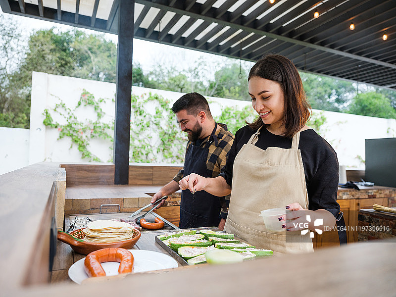 快乐情侣在露台厨房烧烤图片素材