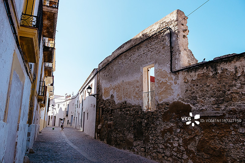 在达尔特维拉老城区空旷的街道上玩球的小男孩图片素材