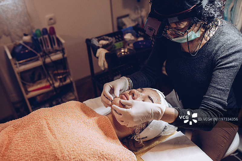 年轻女人在美容院接受清洁护理图片素材