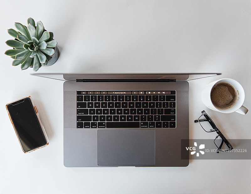带有笔记本电脑、手机、眼镜和咖啡的工作区俯视图图片素材