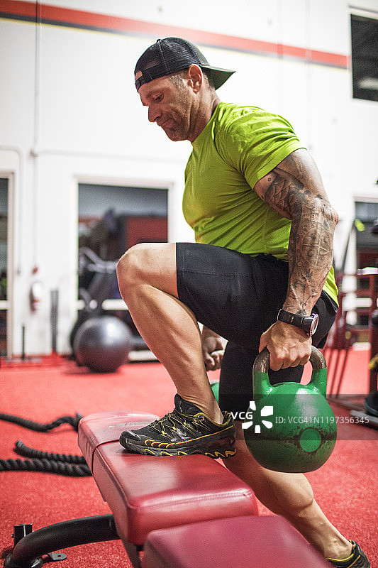 举重运动员在健身房用壶铃锻炼图片素材