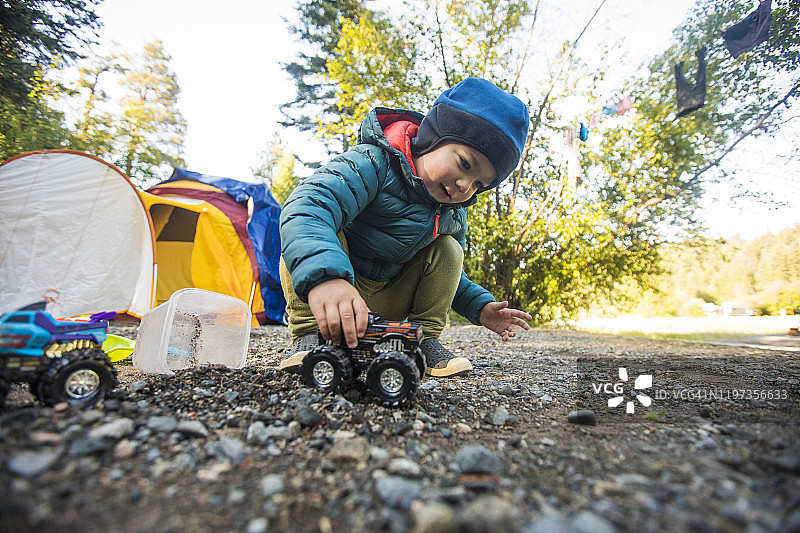 幼儿男孩驾驶怪物卡车穿越泥土和岩石图片素材
