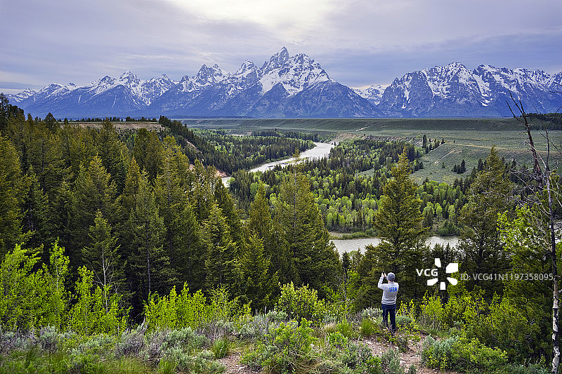 男人在蛇河大提顿山脉用手机拍照图片素材