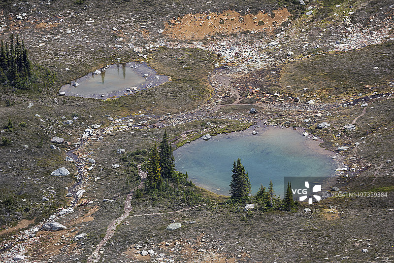 惠斯勒山上一个小型高山湖泊，在多云的夏日里呈现出鲜艳的蓝色图片素材