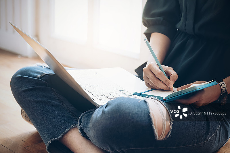 女人手握笔在笔记本上写作特写图片素材