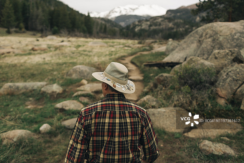 退休男子在落基山国家公园的步道上行走图片素材
