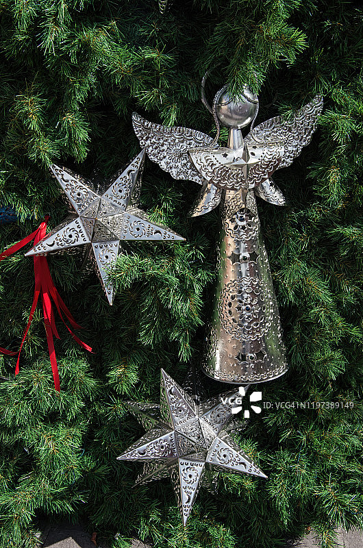 圣诞树上的冲孔锡制摩拉维亚星和天使装饰品图片素材