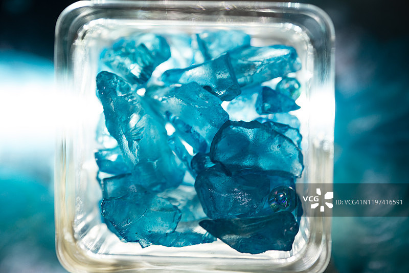 方形玻璃杯中的蓝色海玻璃图片素材