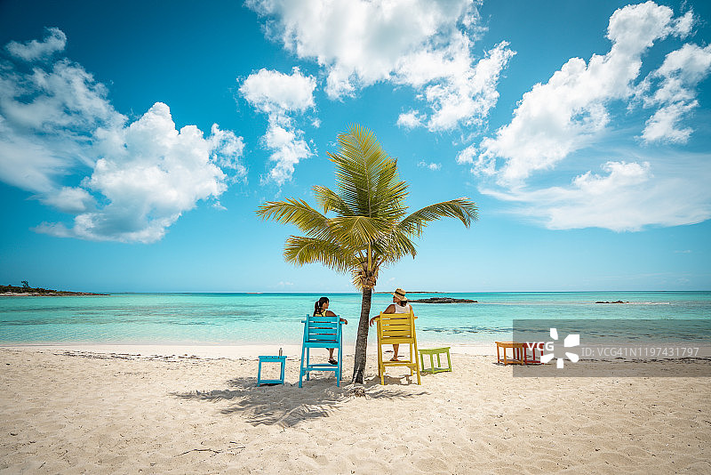 情侣在椰子树下的海滩边图片素材