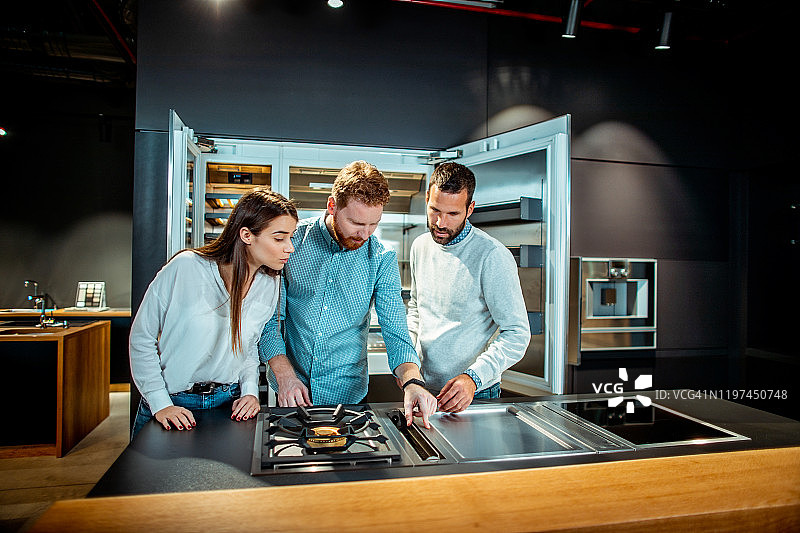 顾客在厨具店选购新型现代炉灶图片素材